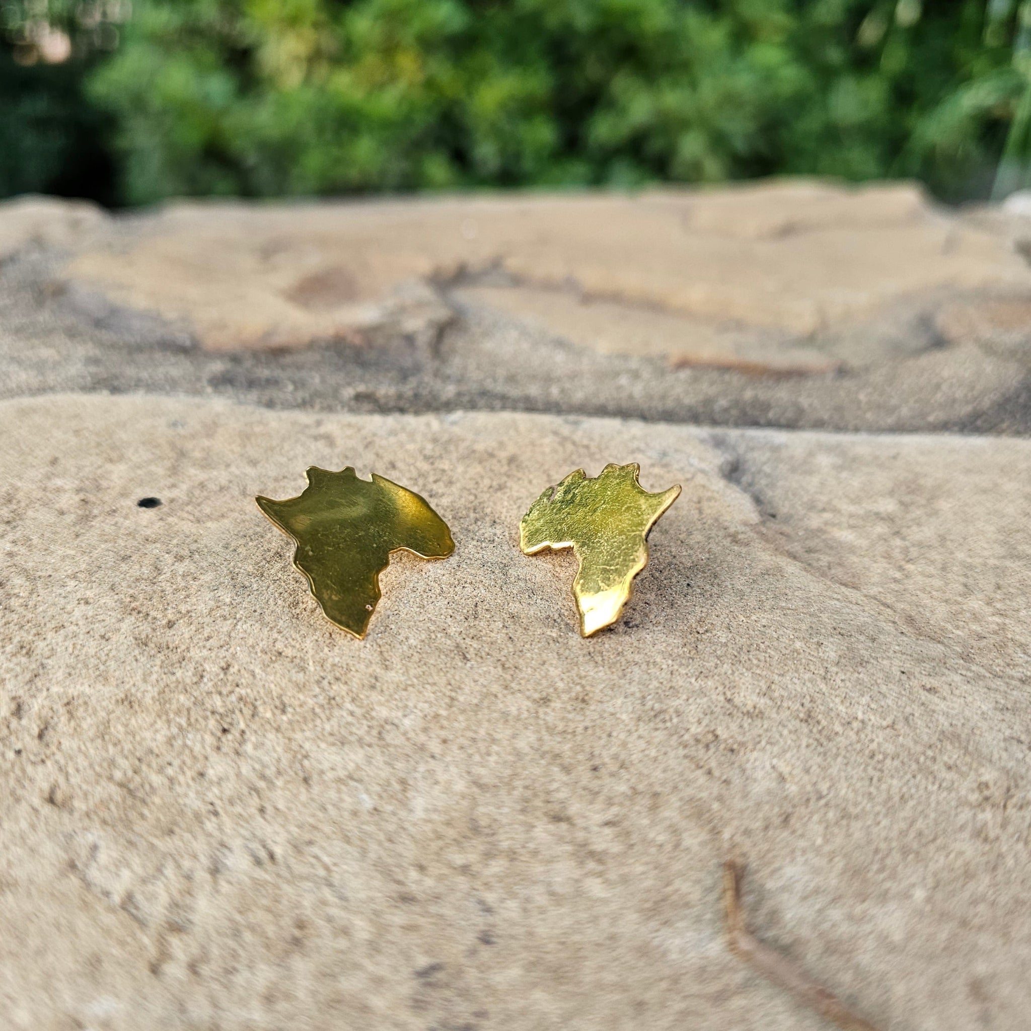 An image of gold-color Minimal Motherland-map studs in polished brass. Shop Kamawe