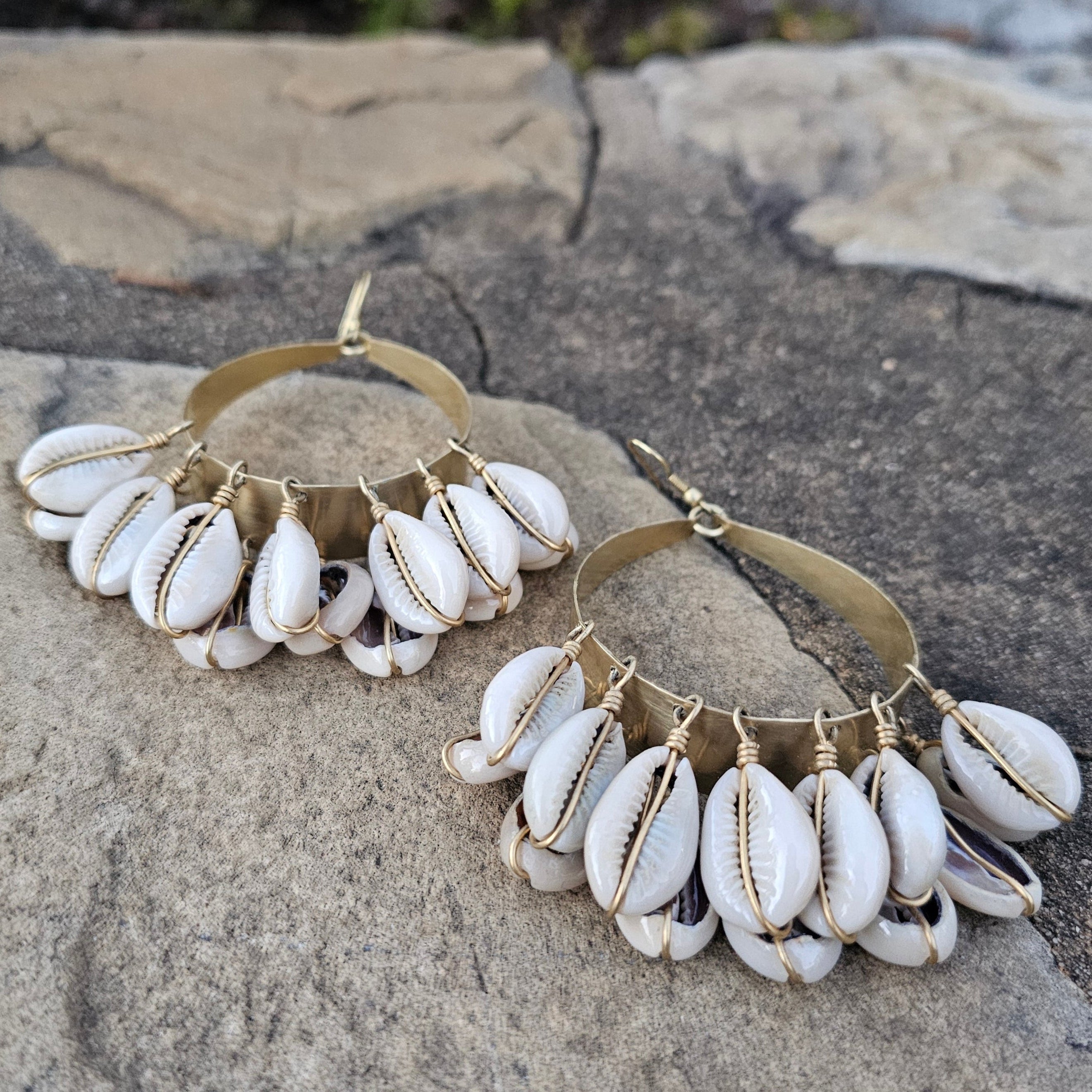 An image of gold & beige-color Swinging doorknocker brass earrings with cowrie. Shop Kamawe