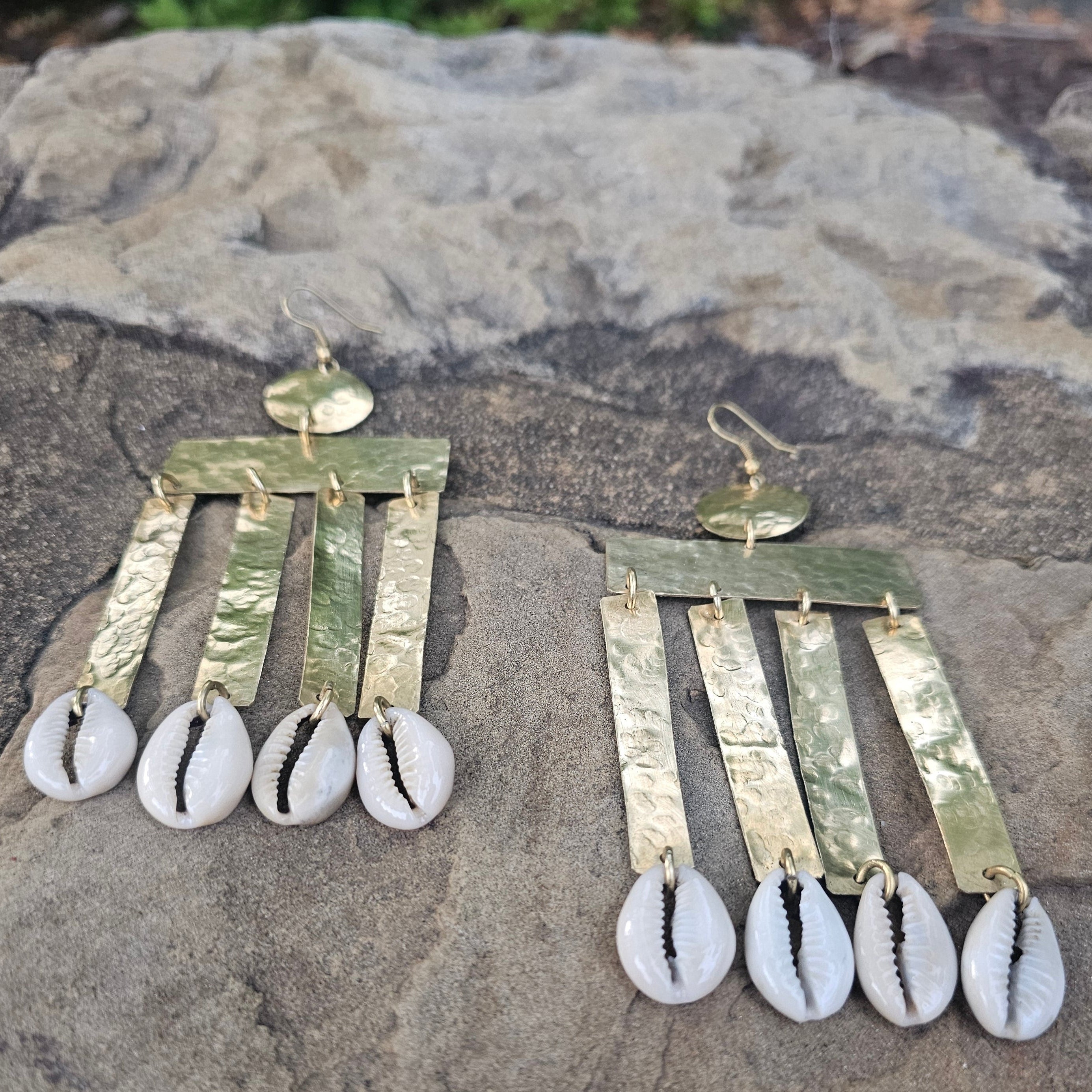 An image of gold & beige-color Ribbed brass column earrings finished with cowrie. Shop Kamawe