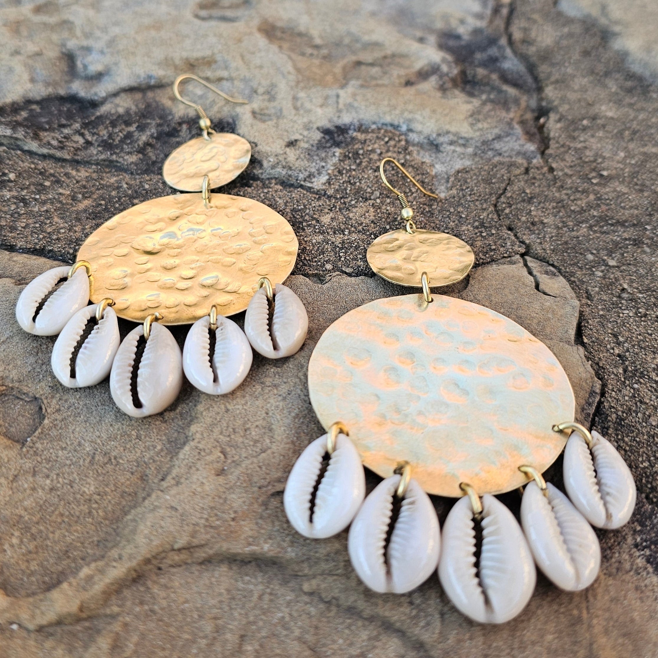 An image of gold & beige-color Two hammered circles with cowrie shells finish. Shop Kamawe
