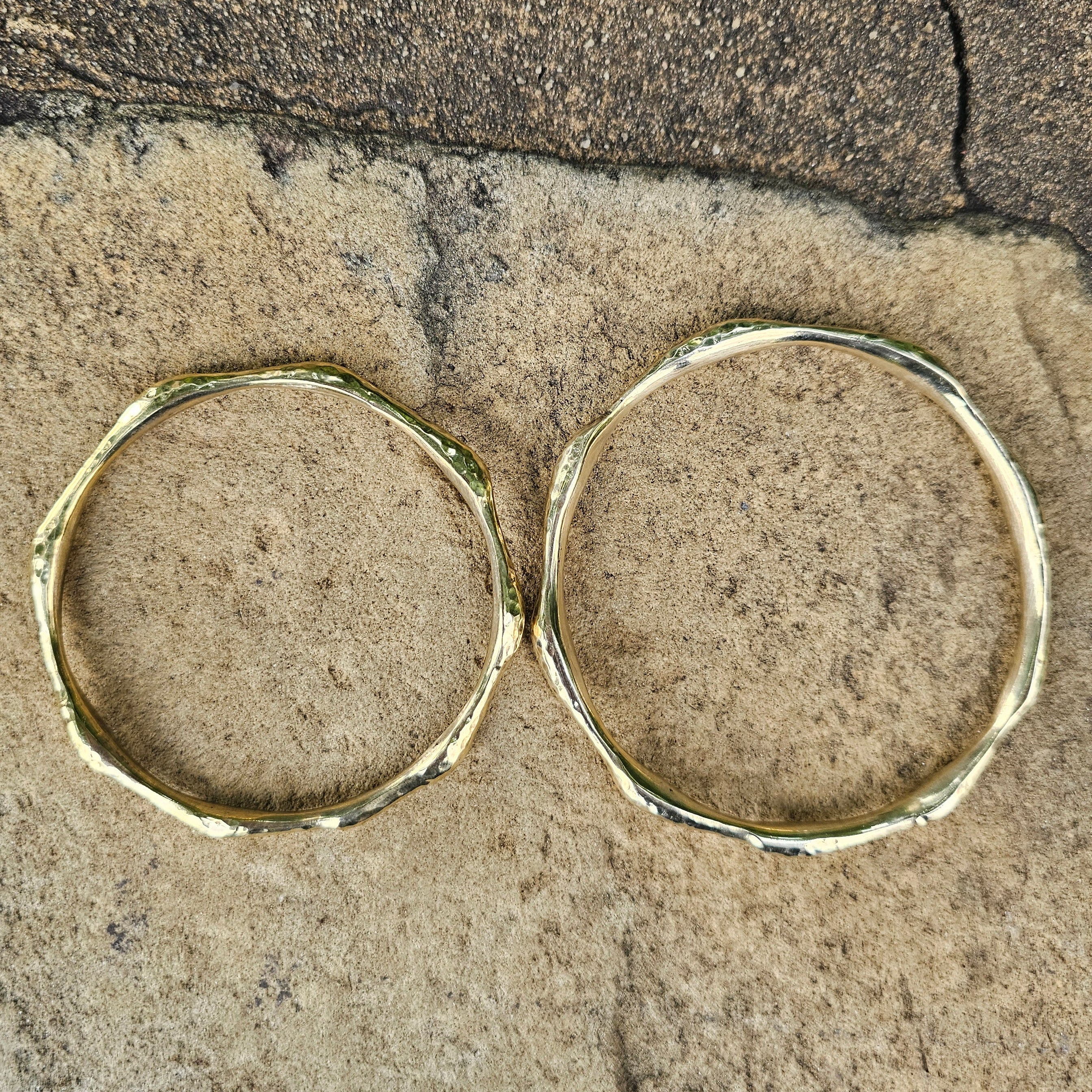 An image of gold-color Bold hammered brass bangle with wave-like texture. Shop Kamawe
