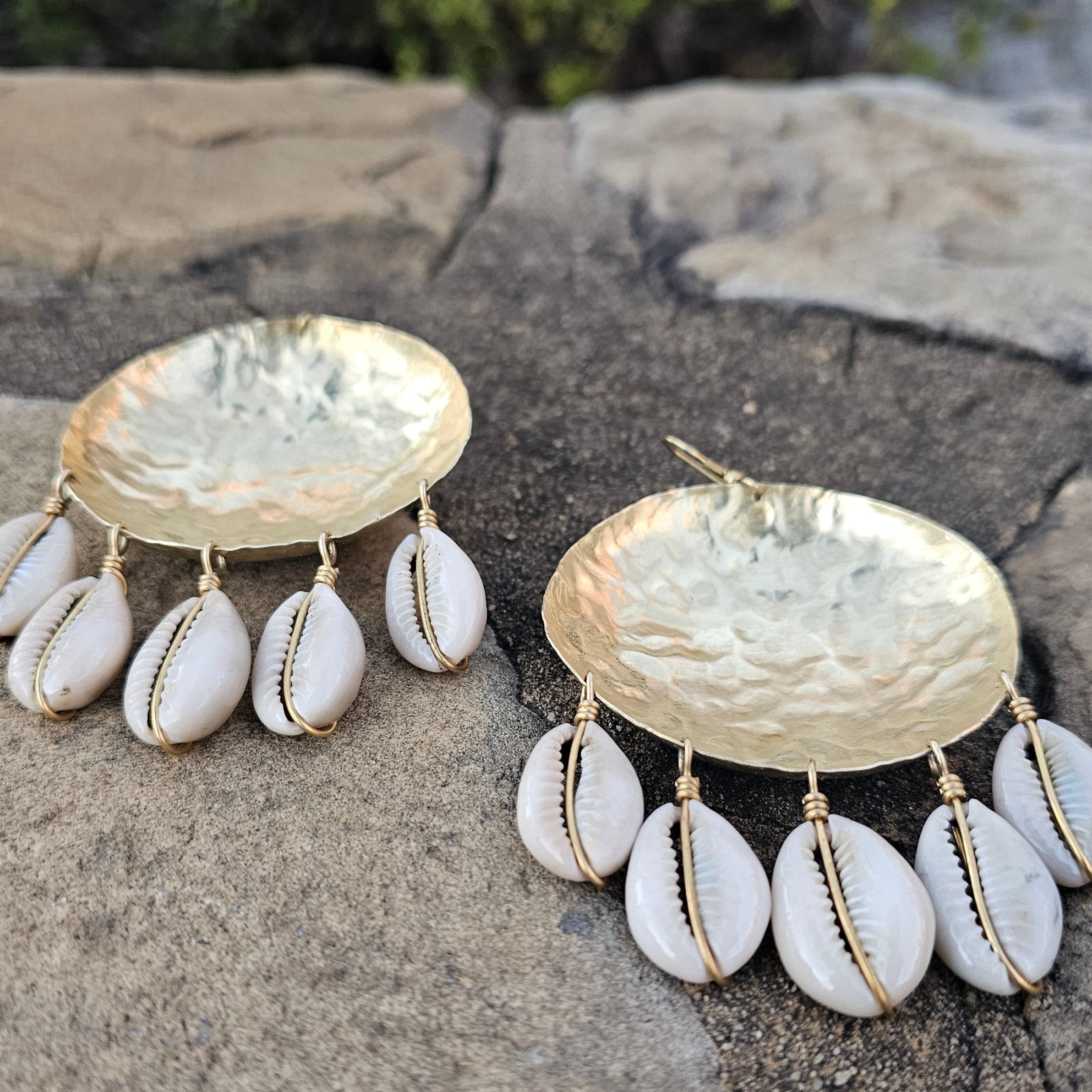 An image of gold & beige-color Bold bowl-shaped brass earrings crowned with cowrie. Shop Kamawe
