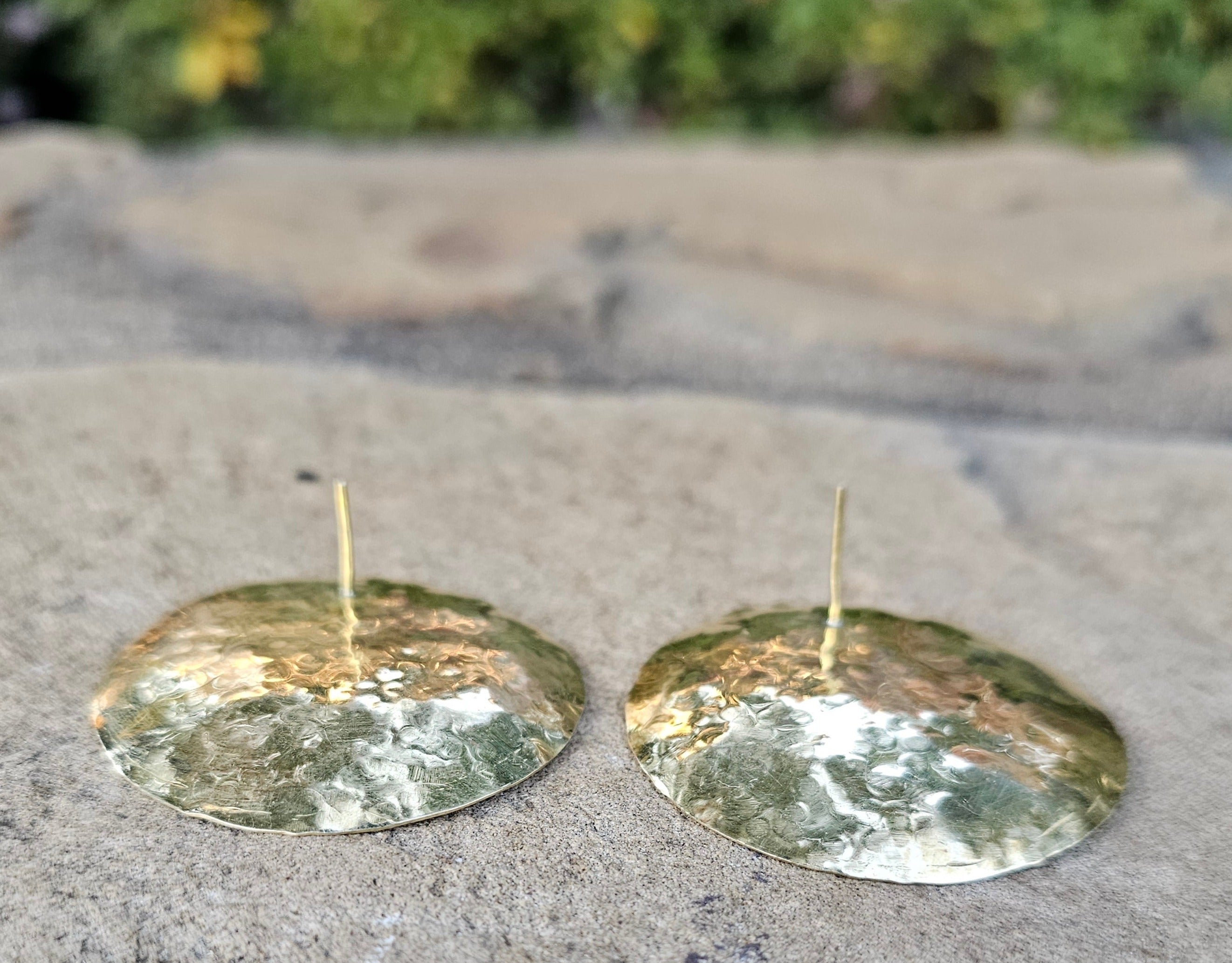 An image of gold-color Oversized hammered brass discs with organic texture. Shop Kamawe