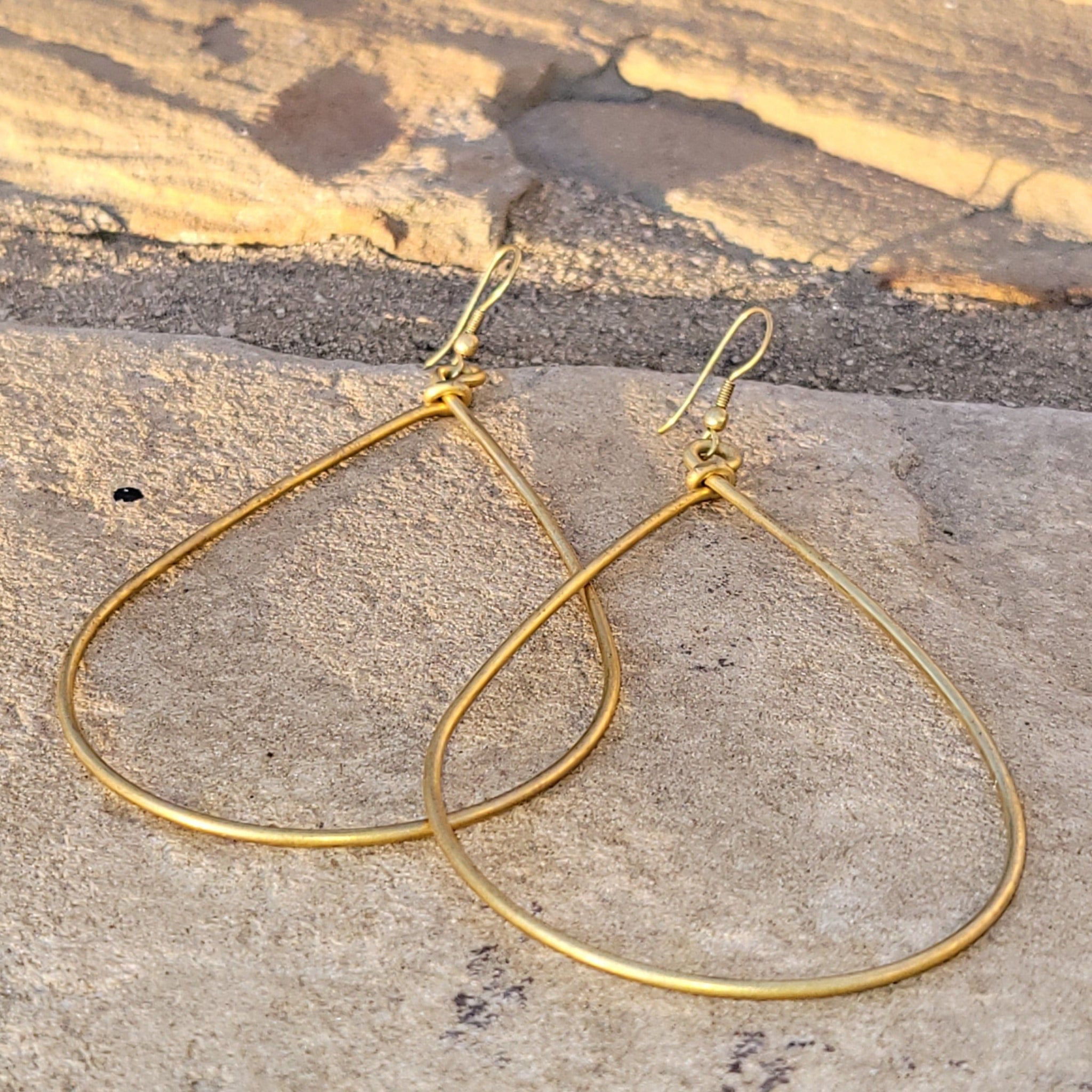 An image of gold-color Bold oversized teardrop drops in smooth brass. Shop Kamawe
