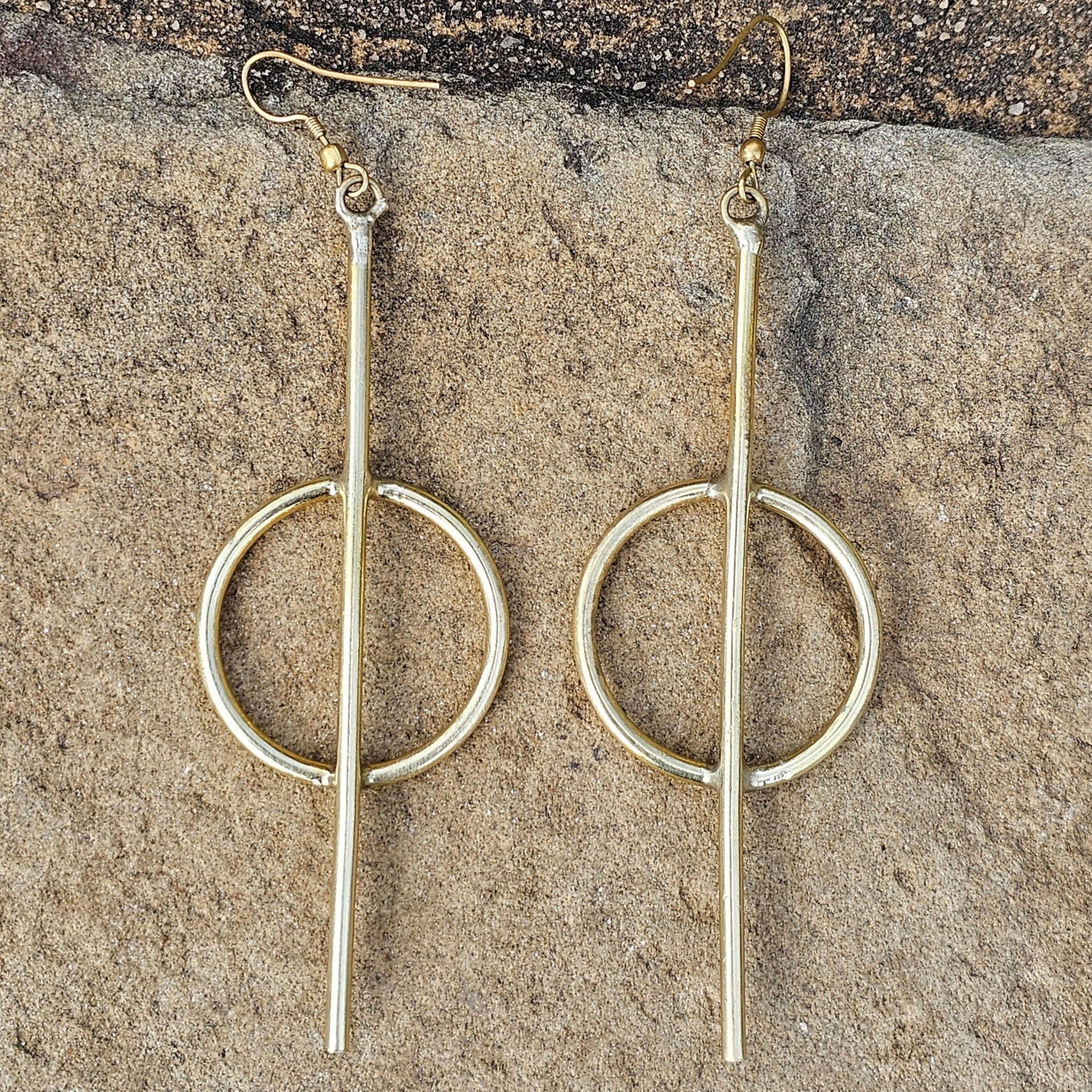 An image of gold-color Medium-length straight-line brass hoops. Shop Kamawe