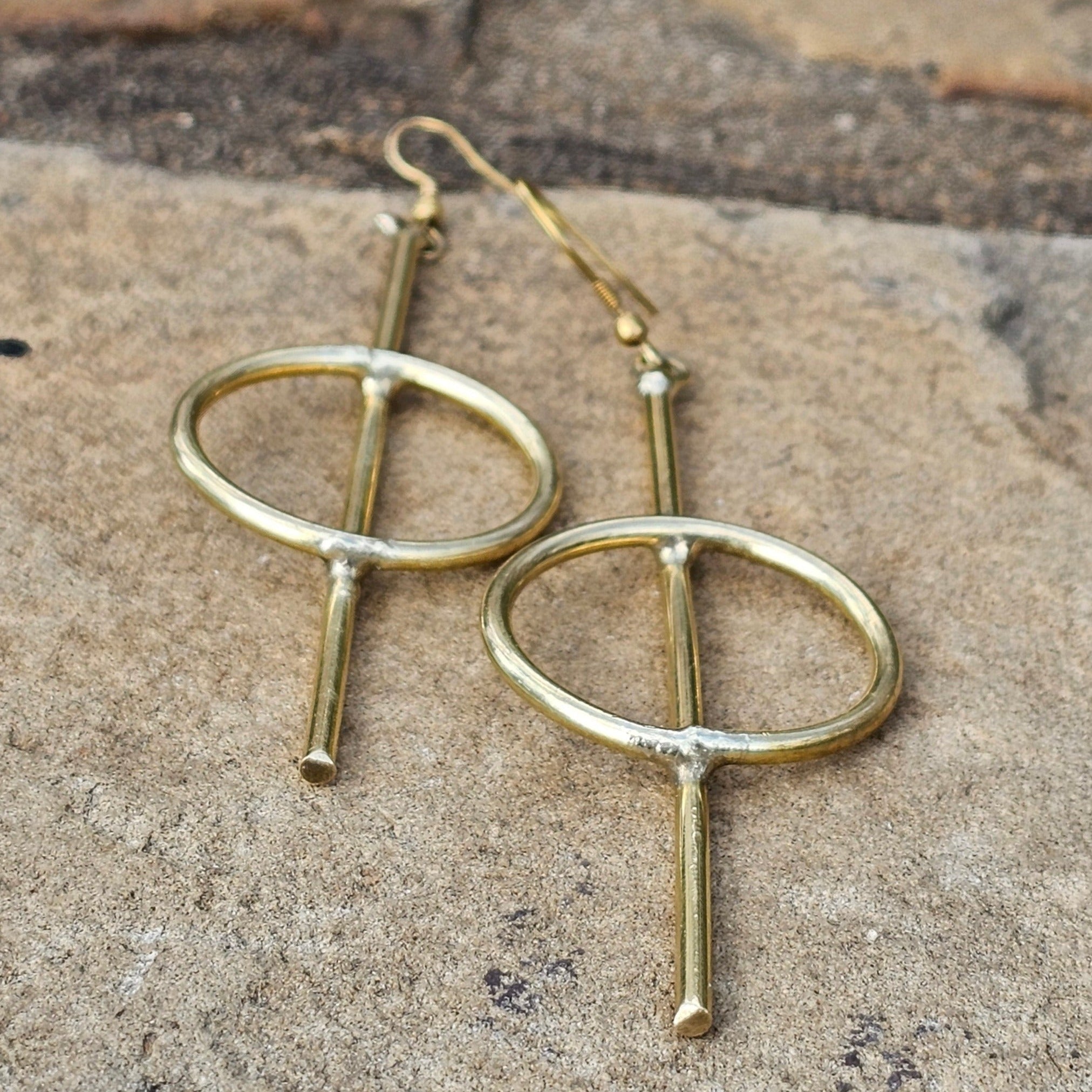 An image of gold-color Medium-length straight-line brass hoops. Shop Kamawe
