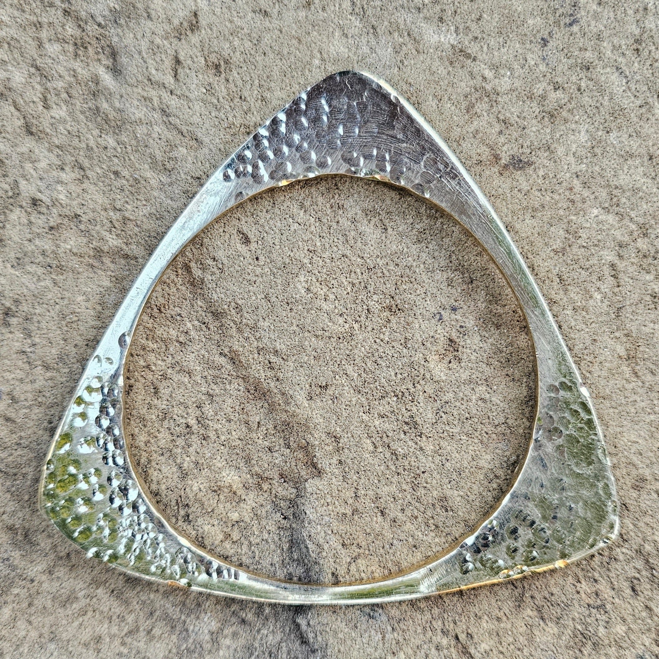 An image of Angular hammered triangle wrapped into a bangle. Shop Kamawe