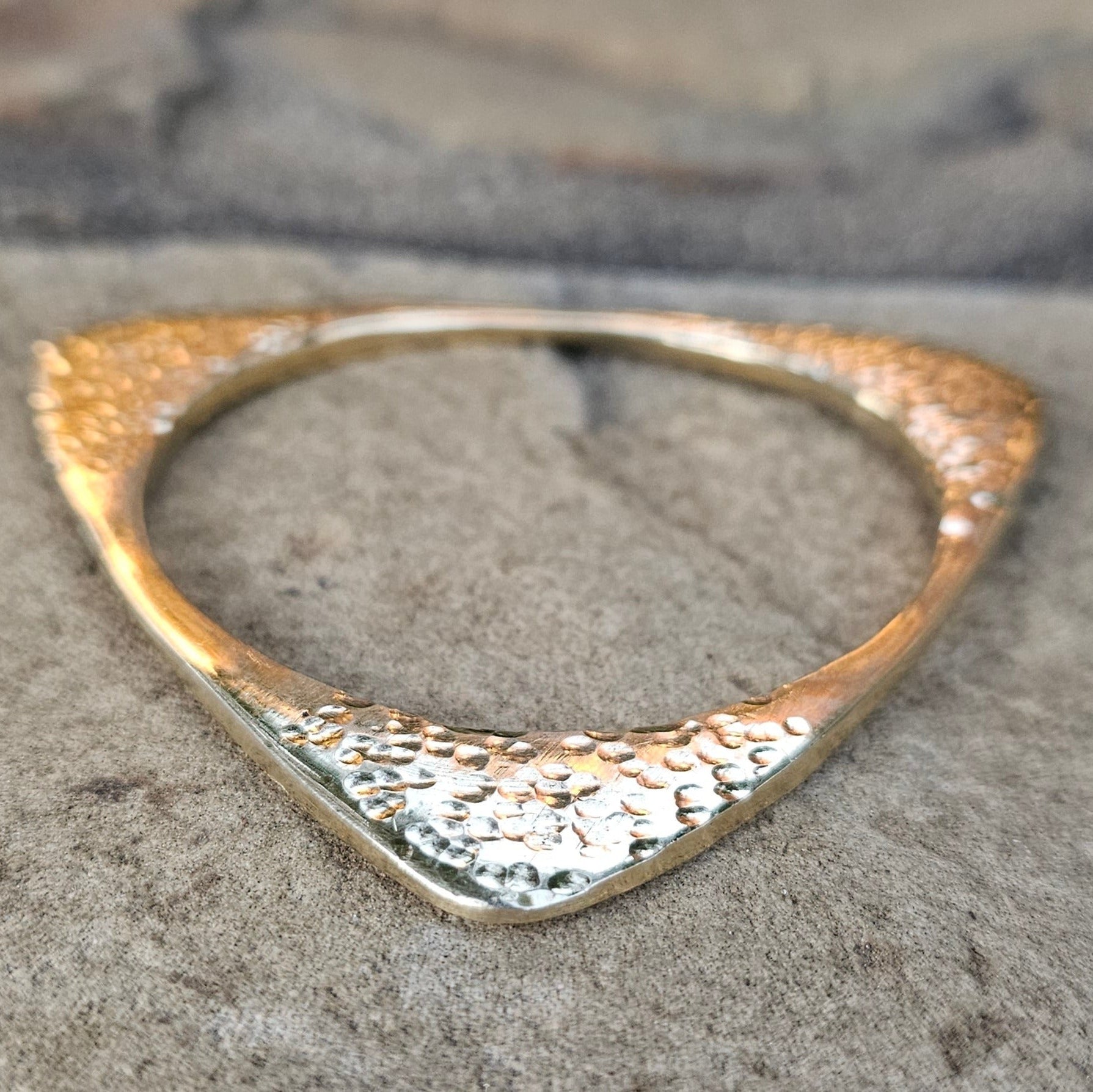 An image of Angular hammered triangle wrapped into a bangle. Shop Kamawe