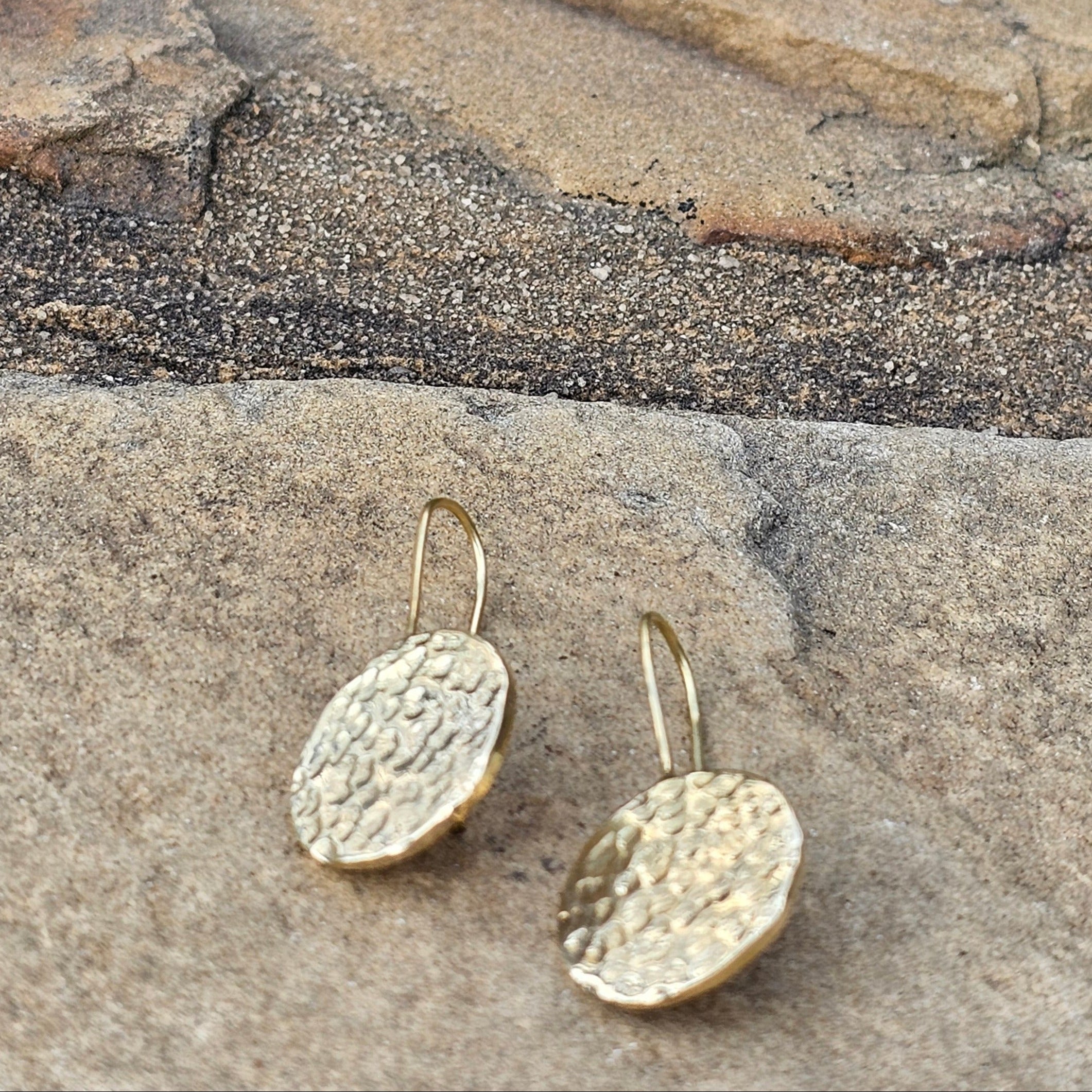 An image of gold-color Textured circular drops on sleek threader wires. Shop Kamawe