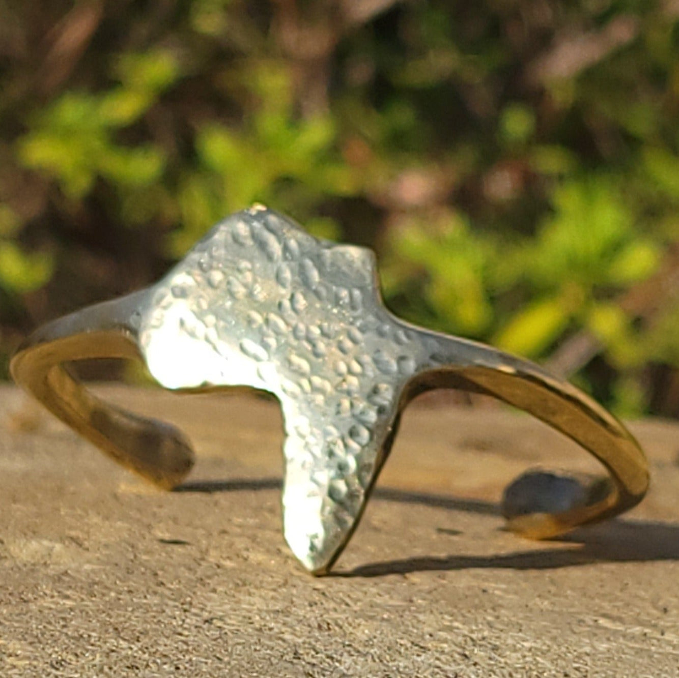 An image of gold-color Textured Motherland-map motif on an open brass cuff. Shop Kamawe