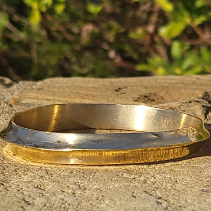 An image of Peak-like ridges shaped into a bold brass bangle. Shop Kamawe
