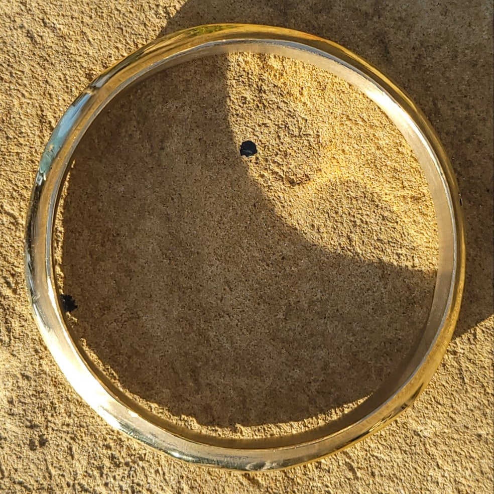 An image of Peak-like ridges shaped into a bold brass bangle. Shop Kamawe