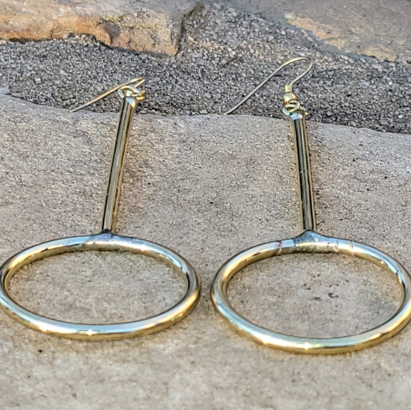 An image of gold-color Narrow elongated brass hoops for everyday wear. Shop Kamawe