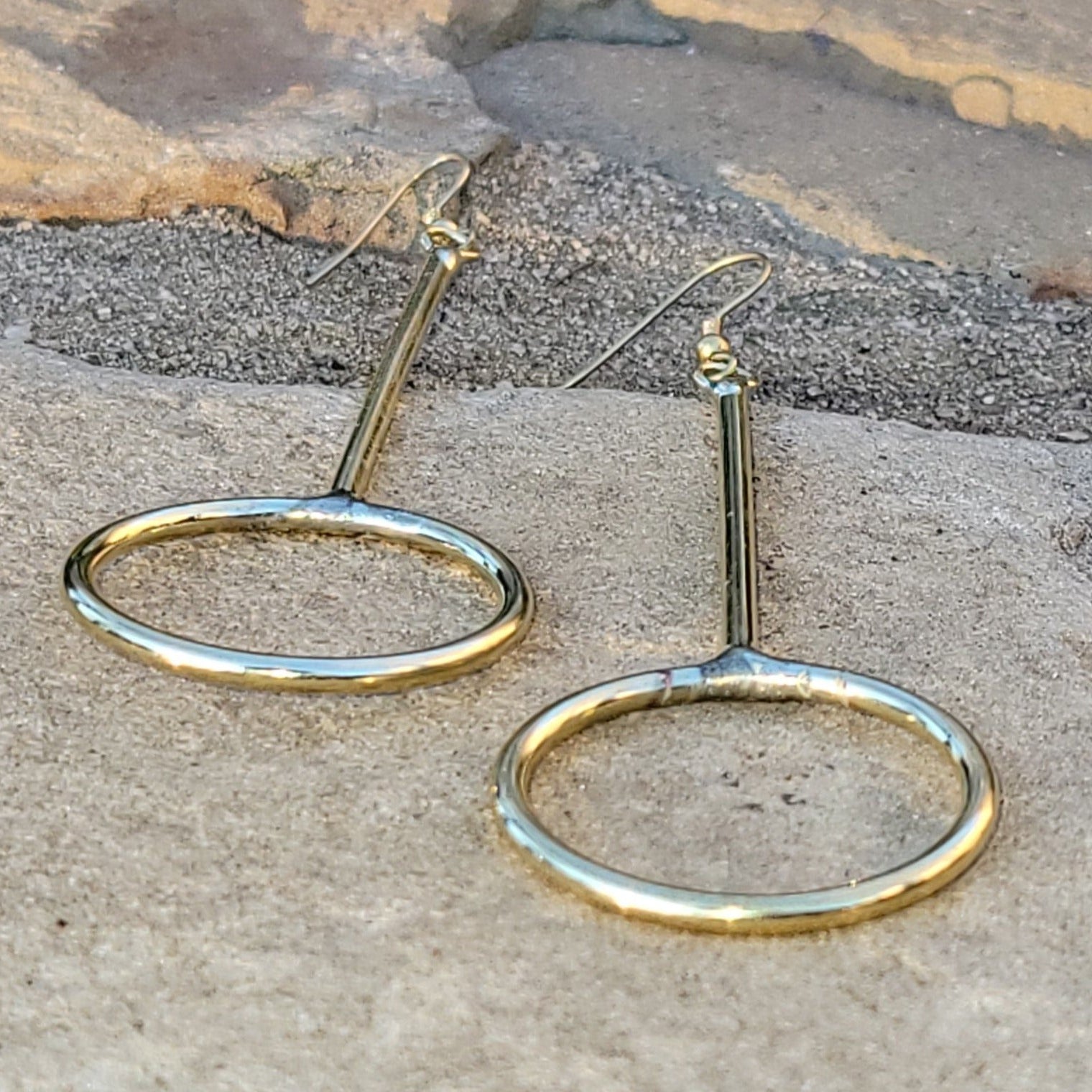 An image of gold-color Narrow elongated brass hoops for everyday wear. Shop Kamawe
