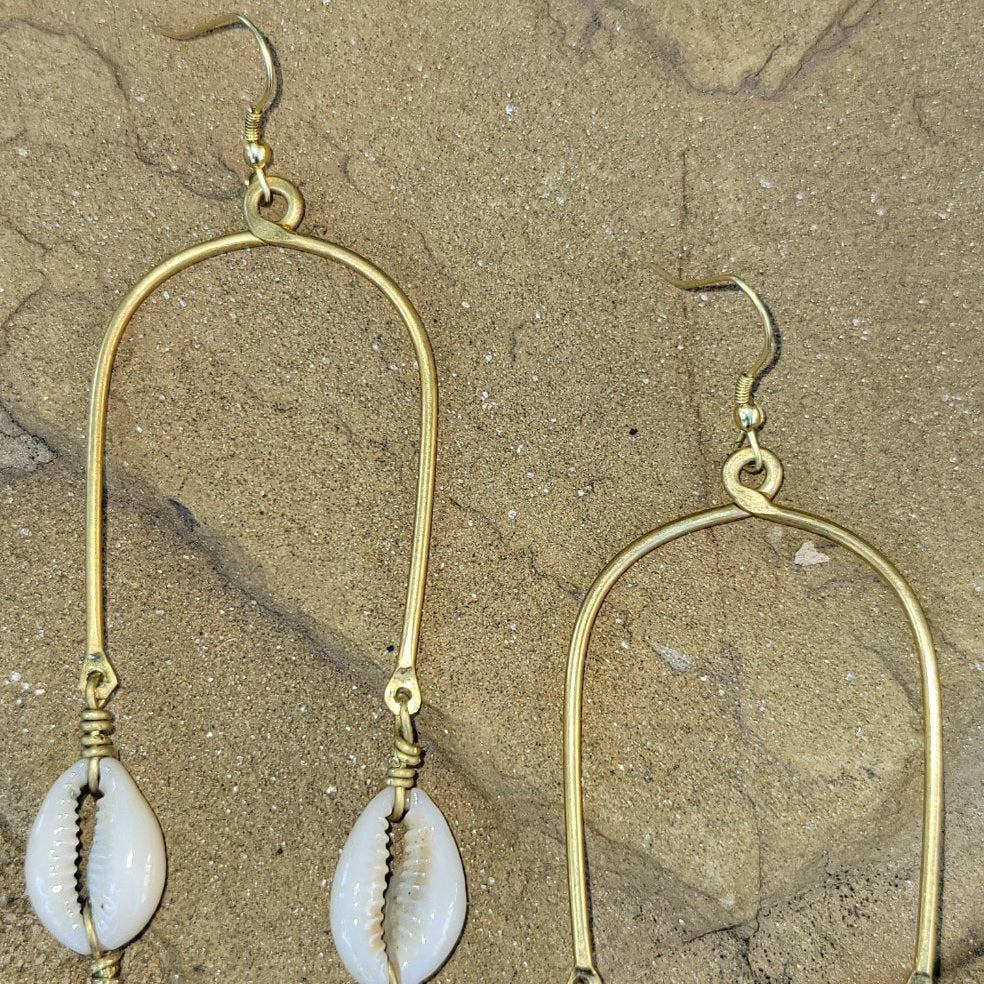 An image of gold & beige-color Long draping brass lines tipped with cowrie shells. Shop Kamawe