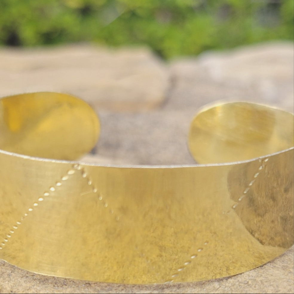 An image of gold-color Deep stamped patterns pressed into a solid brass cuff. Shop Kamawe