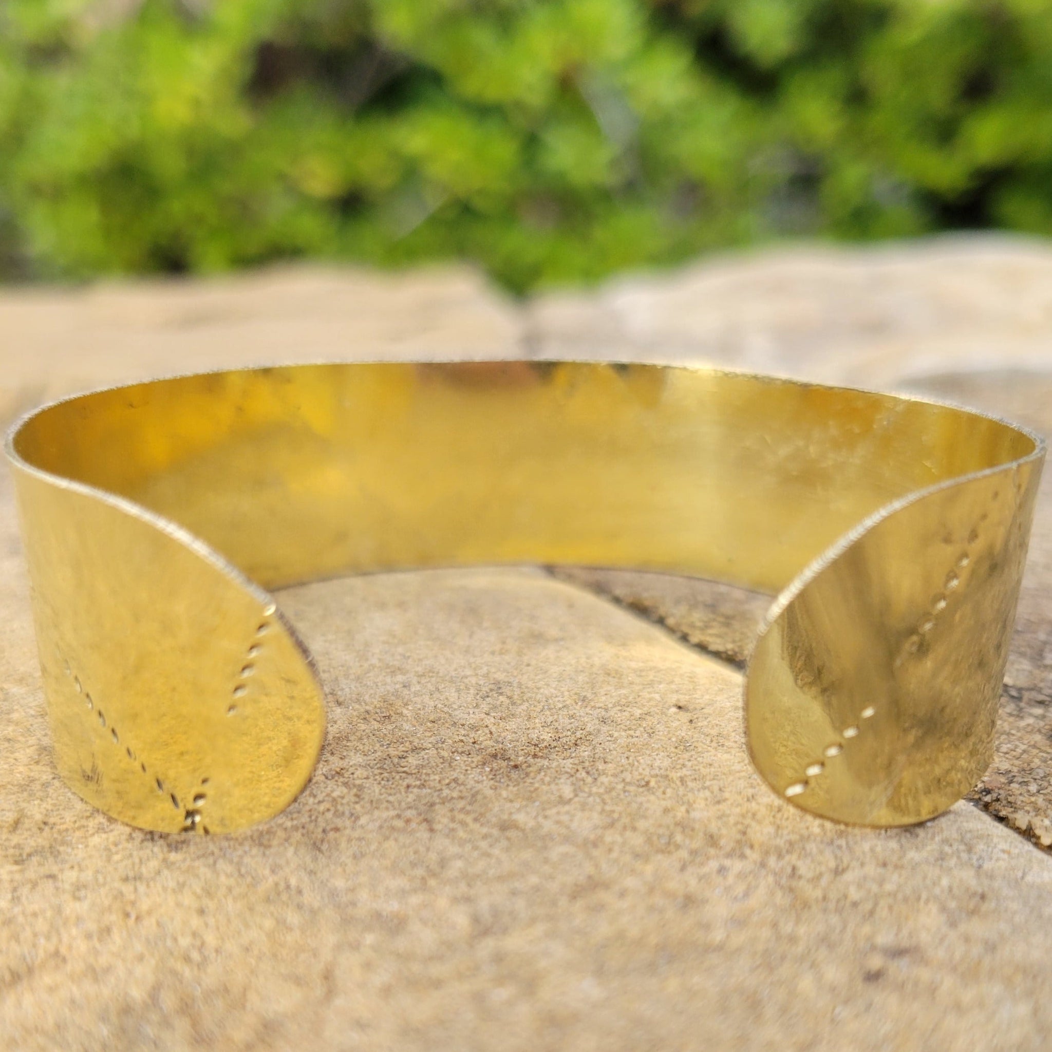 An image of gold-color Deep stamped patterns pressed into a solid brass cuff. Shop Kamawe