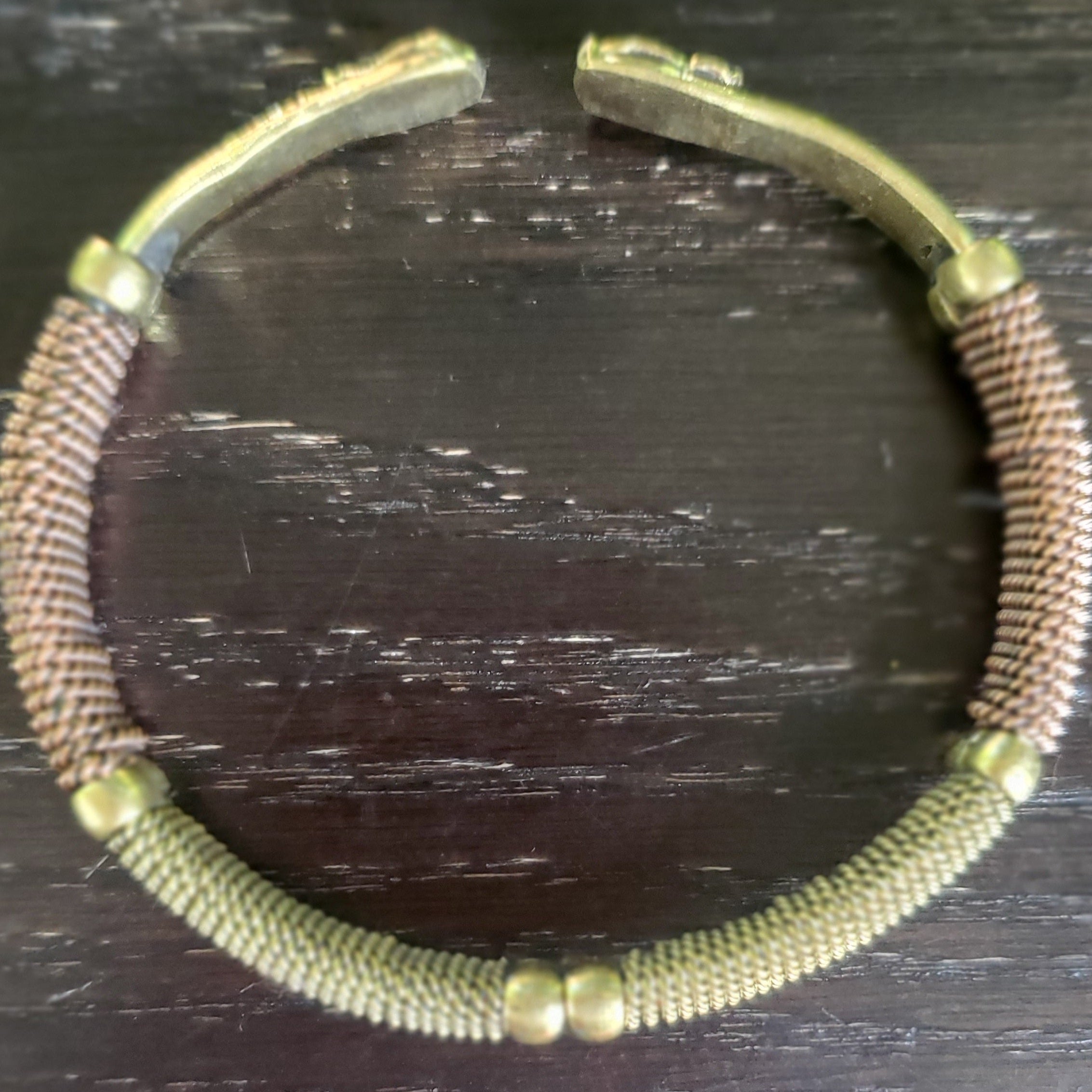 An image of Two metals wrapped together in a continuous spiral. Shop Kamawe