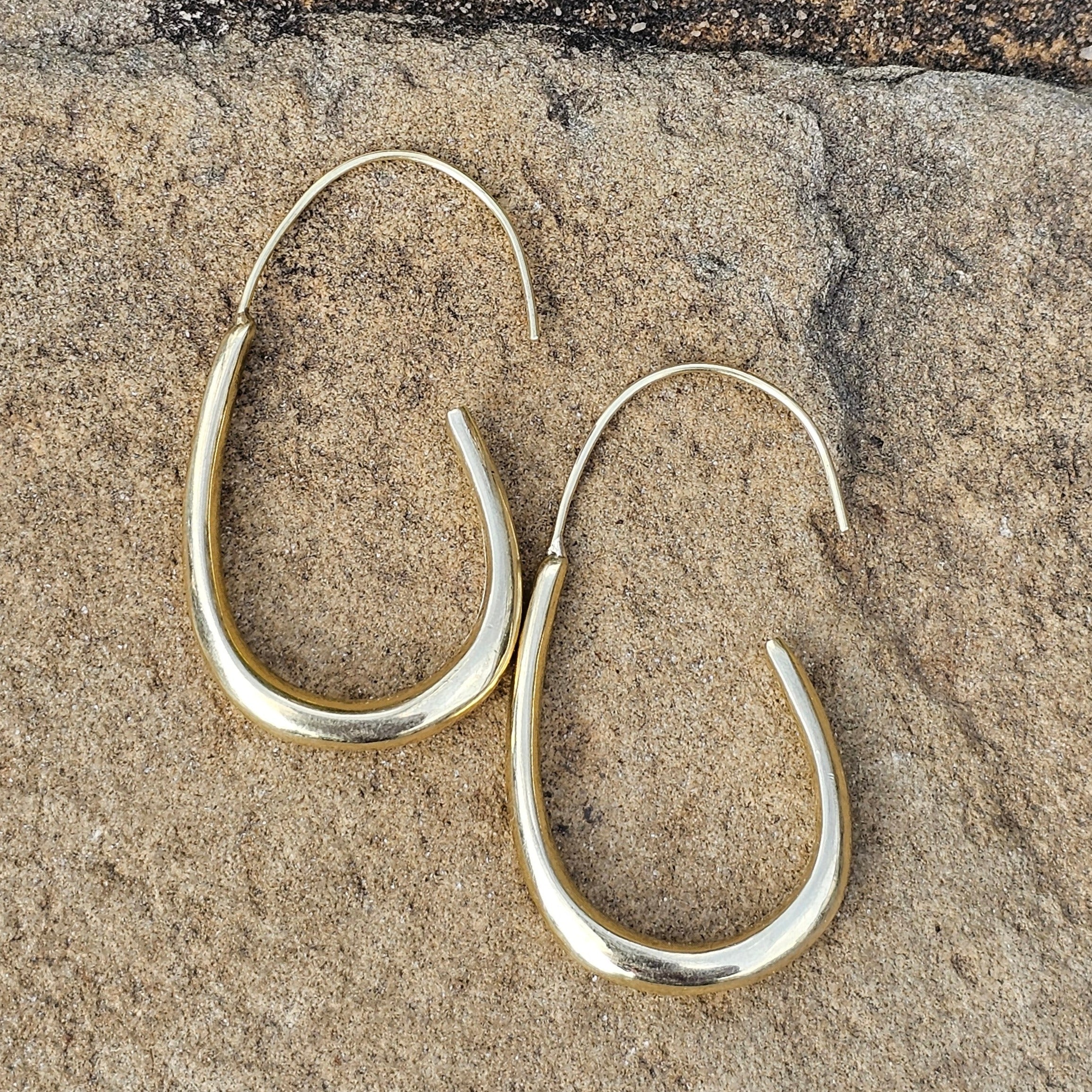 An image of gold-color One unbroken flowing brass line that arcs gently downward. Shop Kamawe
