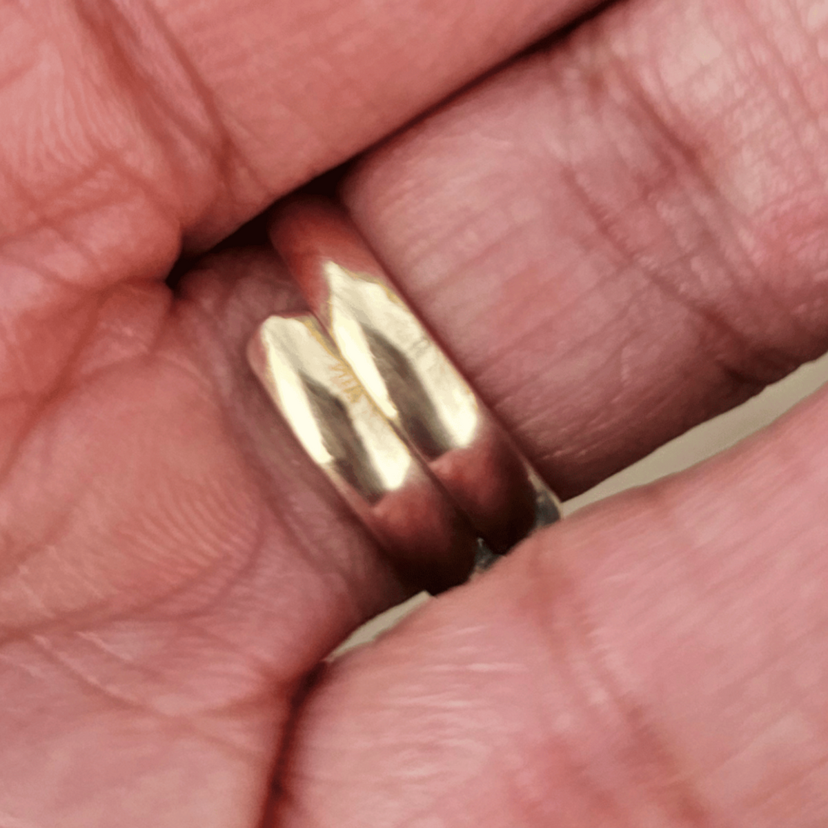 The inside of a gold ring with a large, polished oval black stone, worn on a person's finger. Shop kamawe
