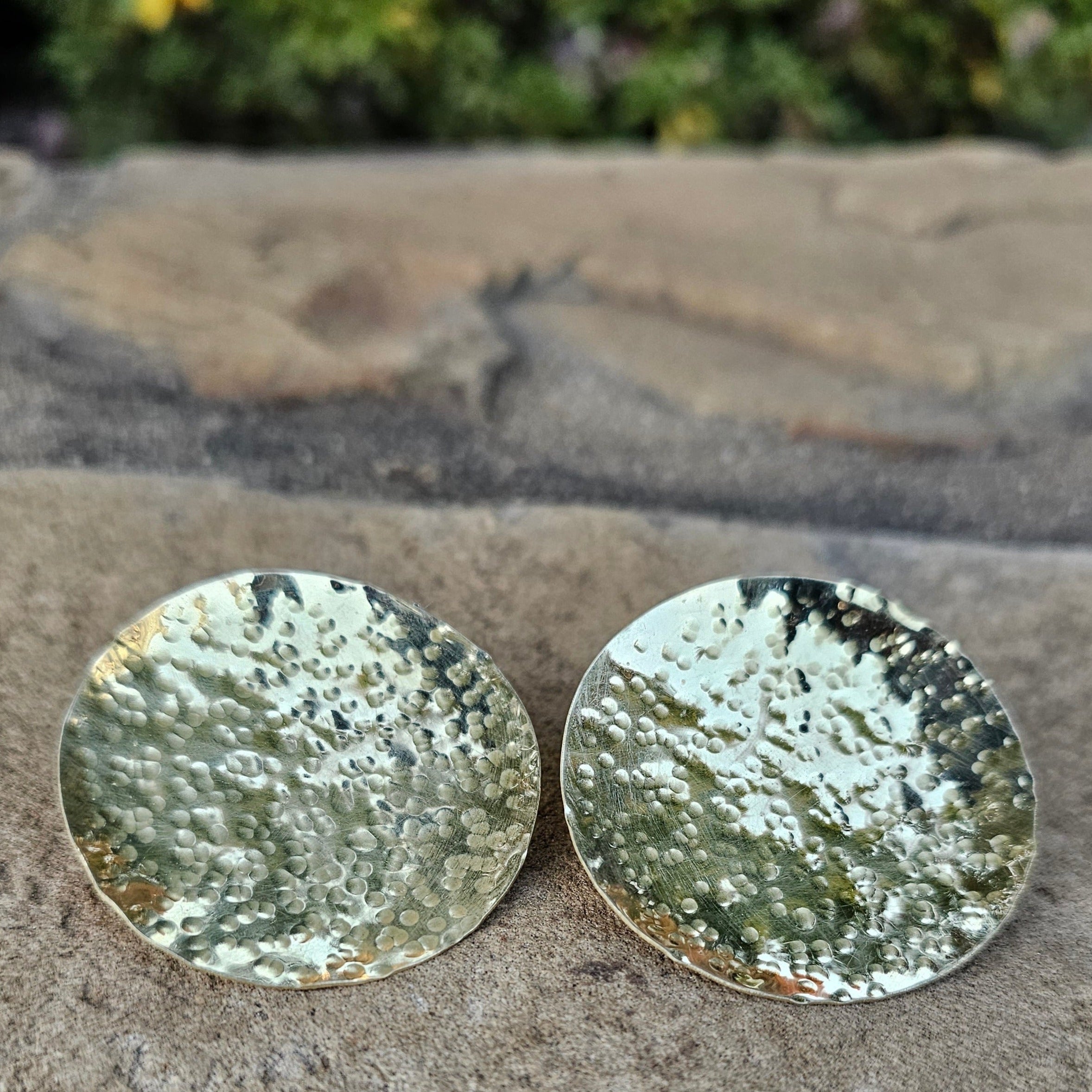 An image of gold-color Oversized hammered brass discs with organic texture. Shop Kamawe
