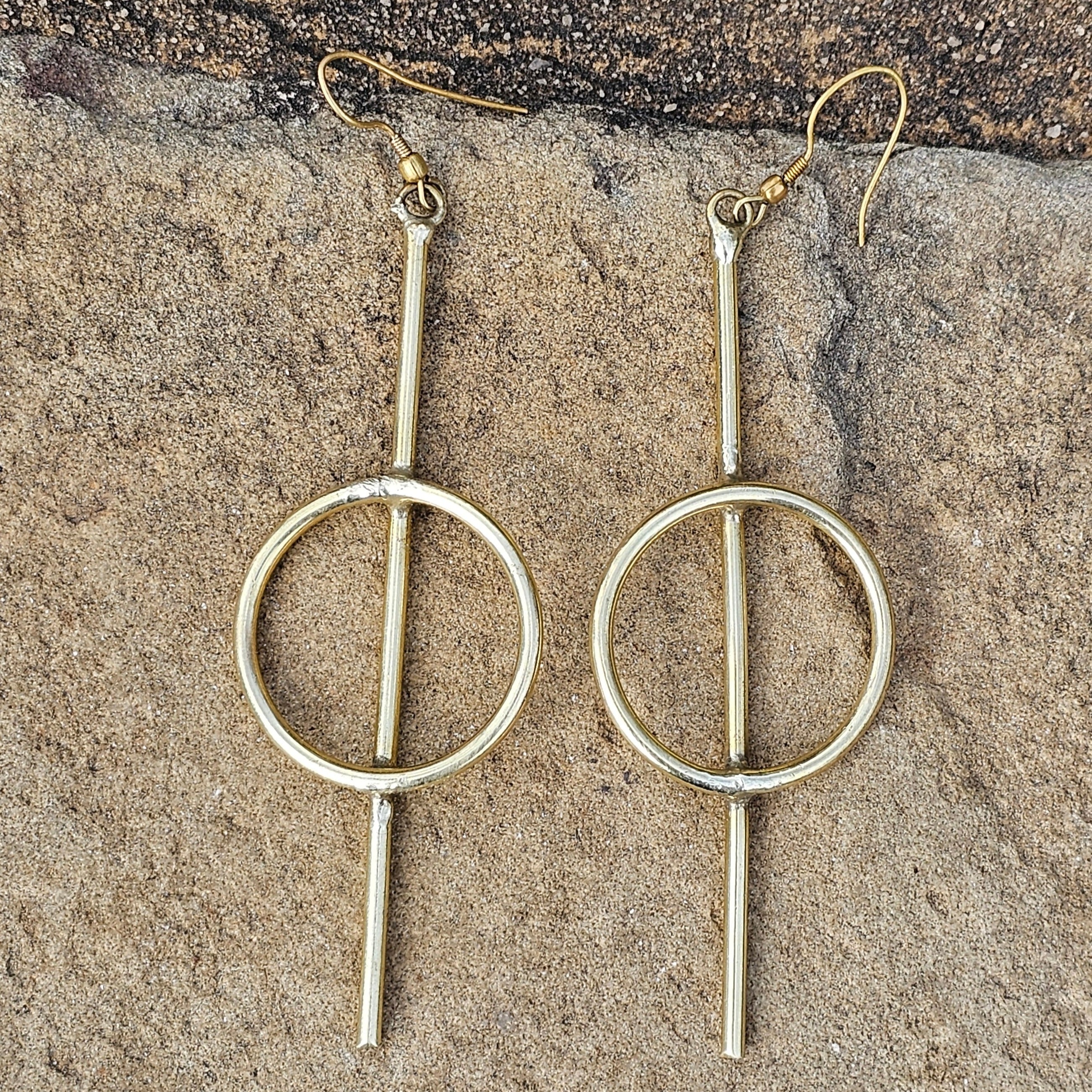 An image of gold-color Medium-length straight-line brass hoops. Shop Kamawe