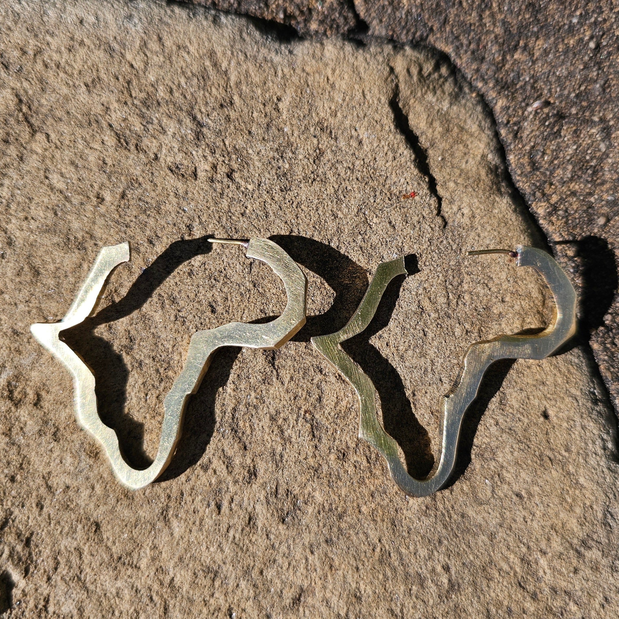 An image of gold-color Minimal open map silhouette in polished brass. Shop Kamawe