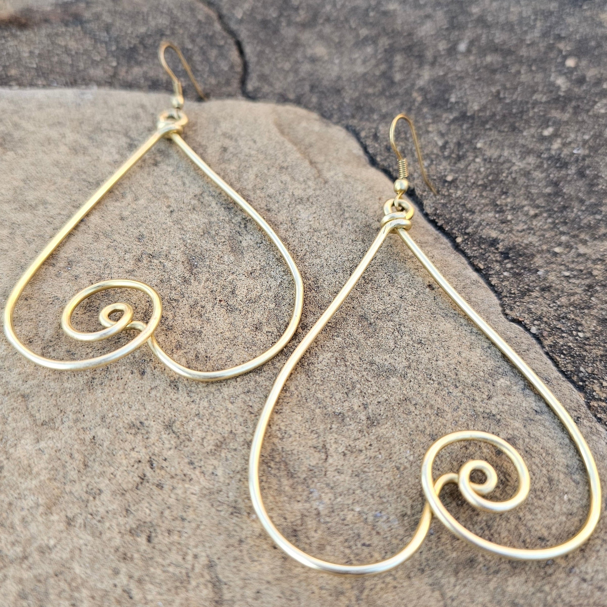 An image of gold-color Interlocked twisted heart brass earrings with romantic flow. Shop Kamawe