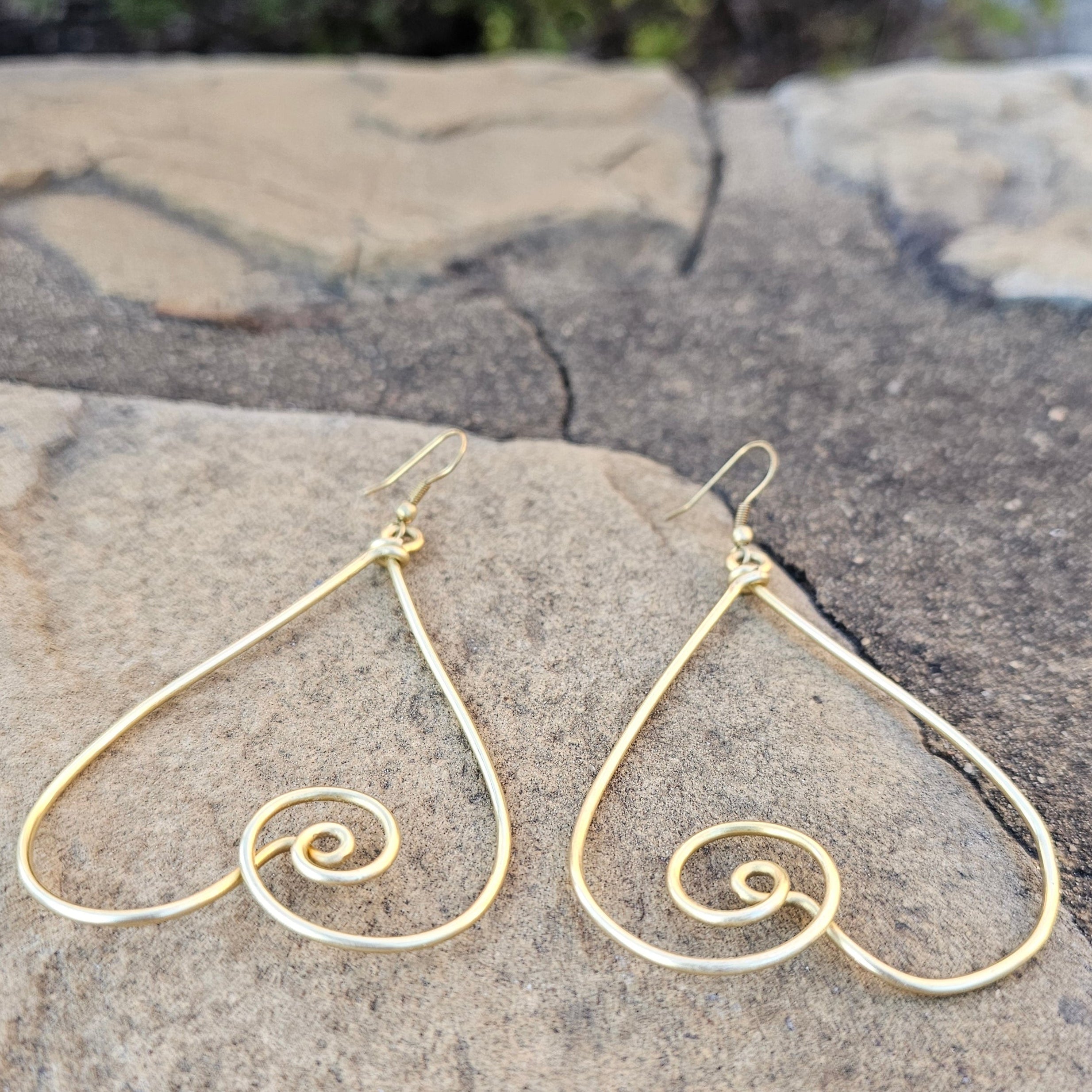 An image of gold-color Interlocked twisted heart brass earrings with romantic flow. Shop Kamawe
