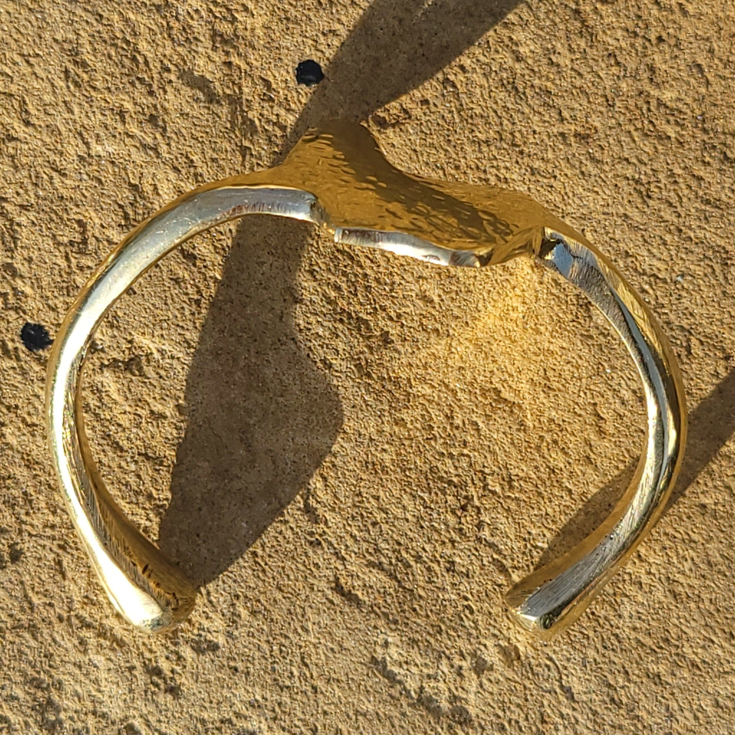 An image of gold-color Textured Motherland-map motif on an open brass cuff. Shop Kamawe
