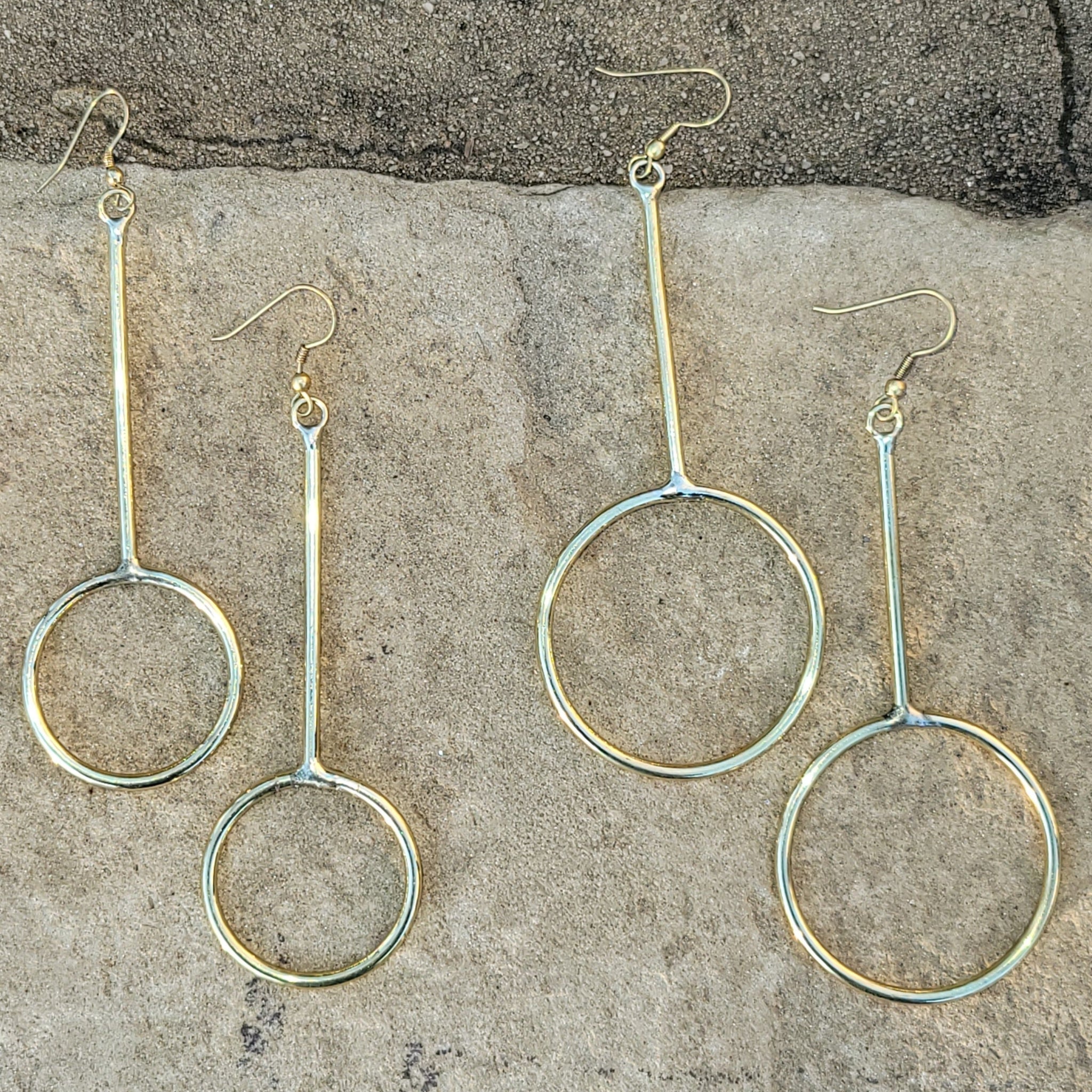 An image of gold-color Long, narrow hoops that stretch the classic silhouette. Shop Kamawe