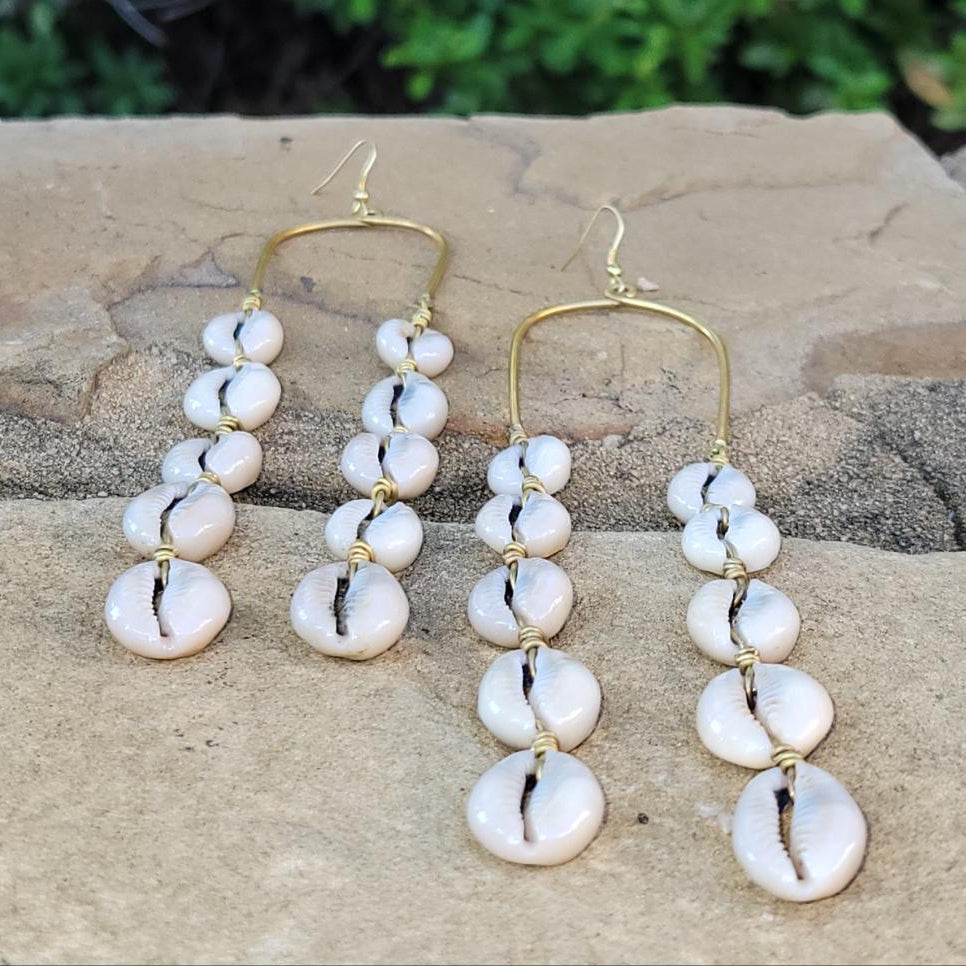 An image of gold & beige-color Long draping brass lines tipped with cowrie shells. Shop Kamawe