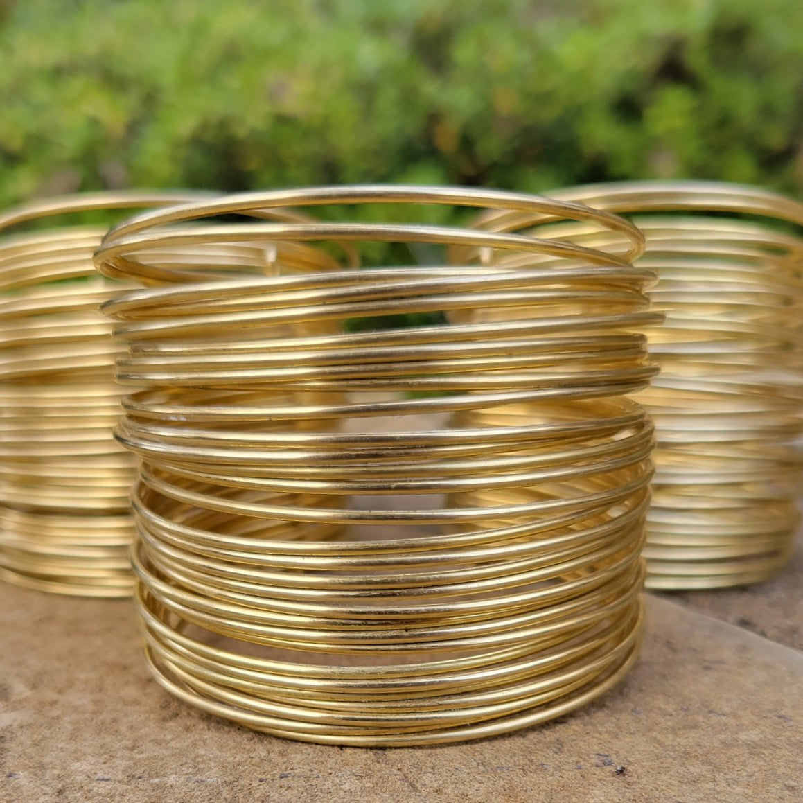 An image of Hand-wrapped wire detailing on a wide brass cuff. Shop Kamawe