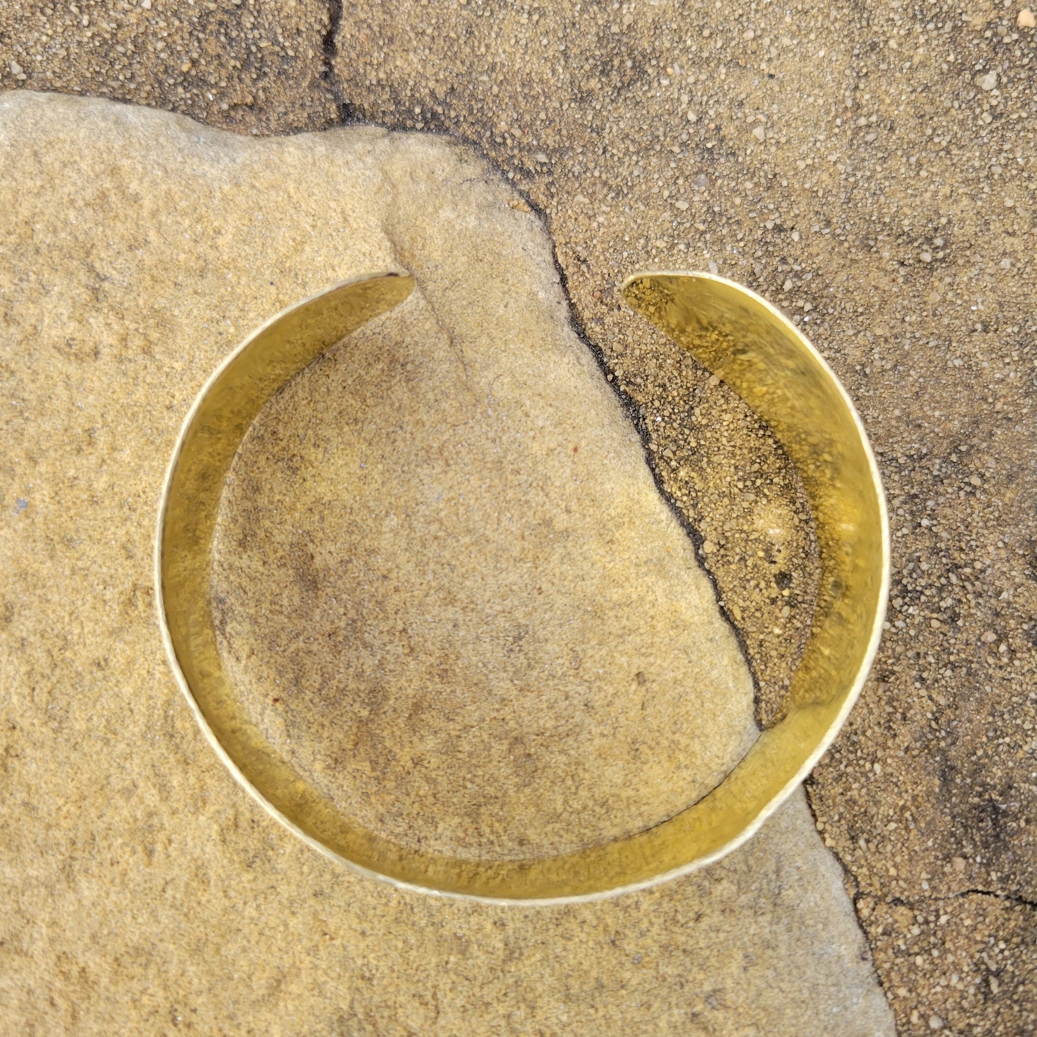 An image of gold-color Deep stamped patterns pressed into a solid brass cuff. Shop Kamawe